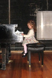 little girl sitting playing the piano