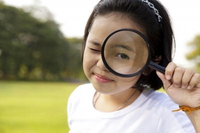 young child looking through a magnifying glass