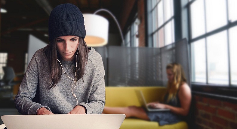 young woman intently focused on laptop